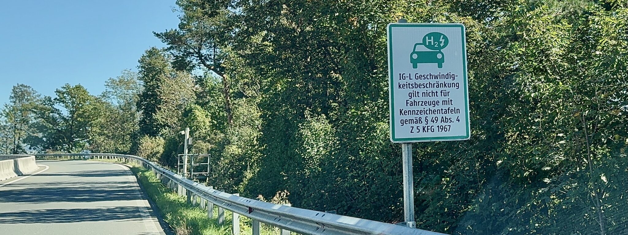 Schild mit Parkplatz mit Ladestationen für Elektroautos in grün und